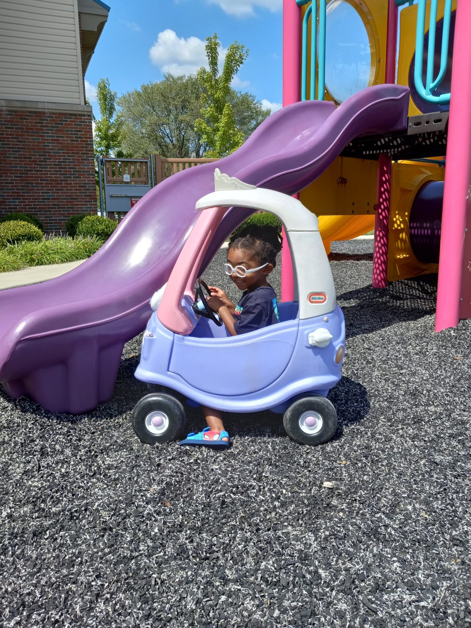 little boy in toy car on playground