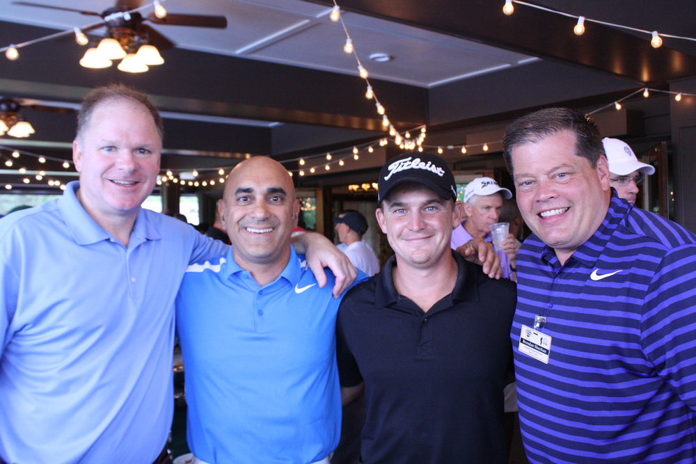 Amateur golfers posing for photo with PGA Touring Pro Bud Cauley