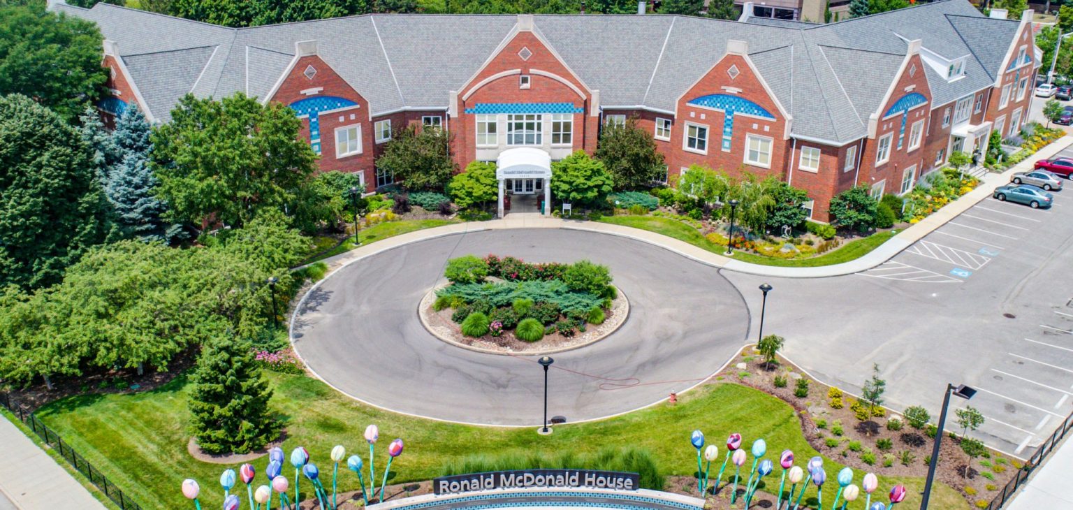 Aerial view of the Ronald McDonald House, a brick building with a circular drive and a garden of tulip sculptures at the entrance