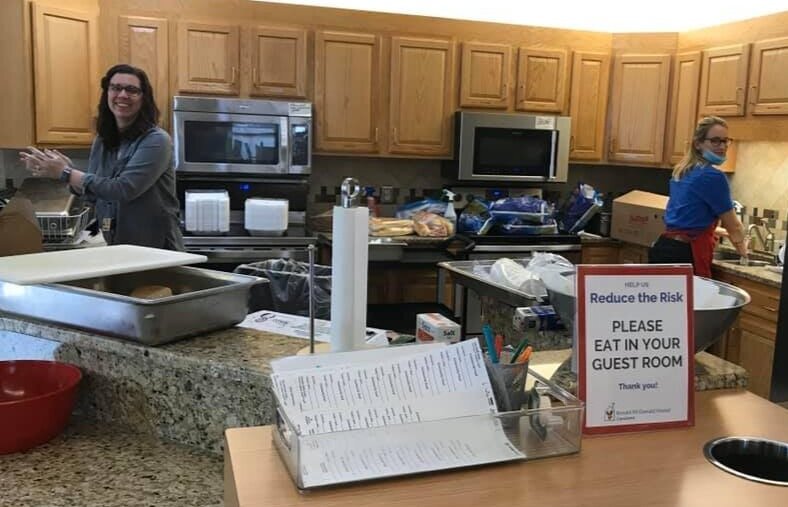 Two volunteers in the kitchen preparing mealas