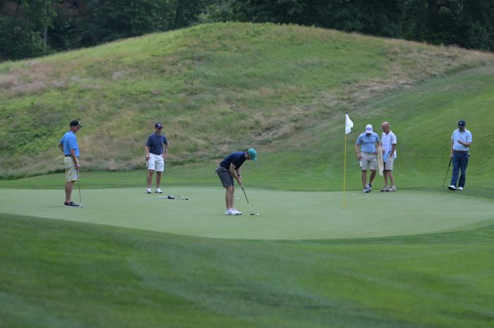 Golfers on putting green.