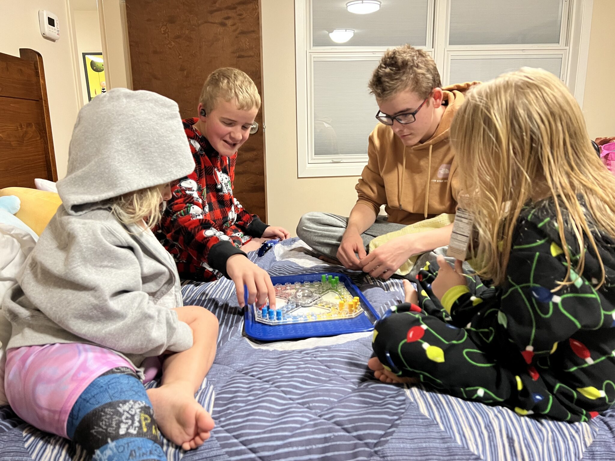 Four children playing a game on a bed