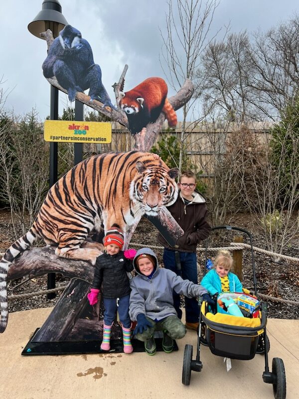 four children with zoo animal sign