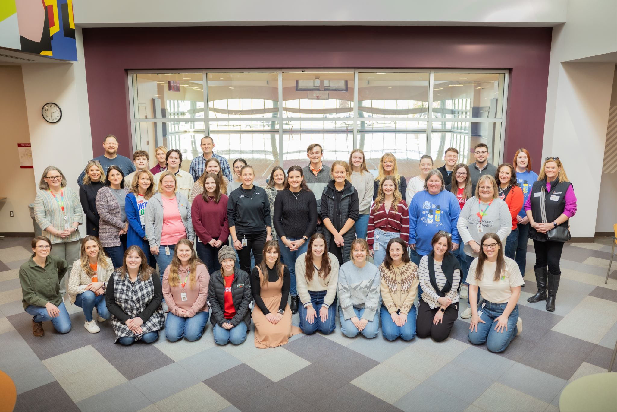 A large group of employee volunteers posing together in a building lobby