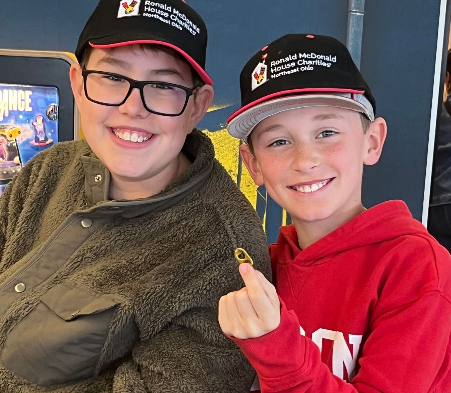 Two boys in RMHC NEO ball caps pose smiling, with a pull tab shown to start their collection.