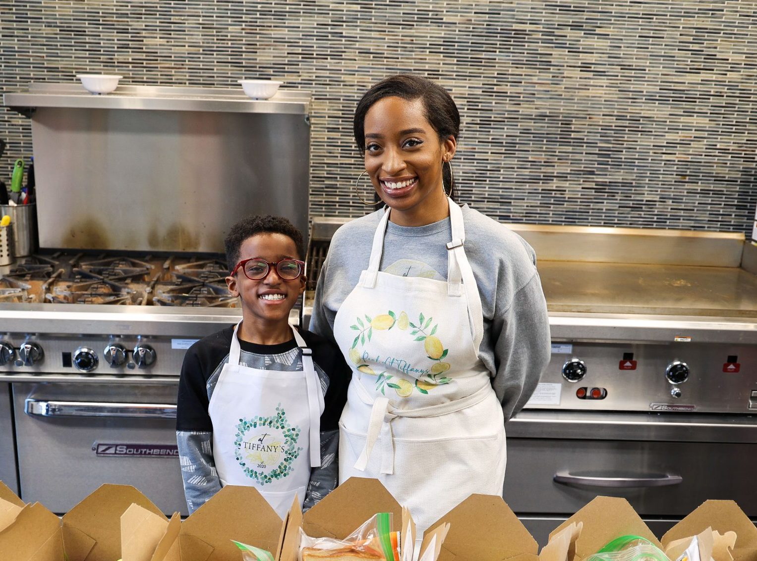 mom and son in front of boxed lunches