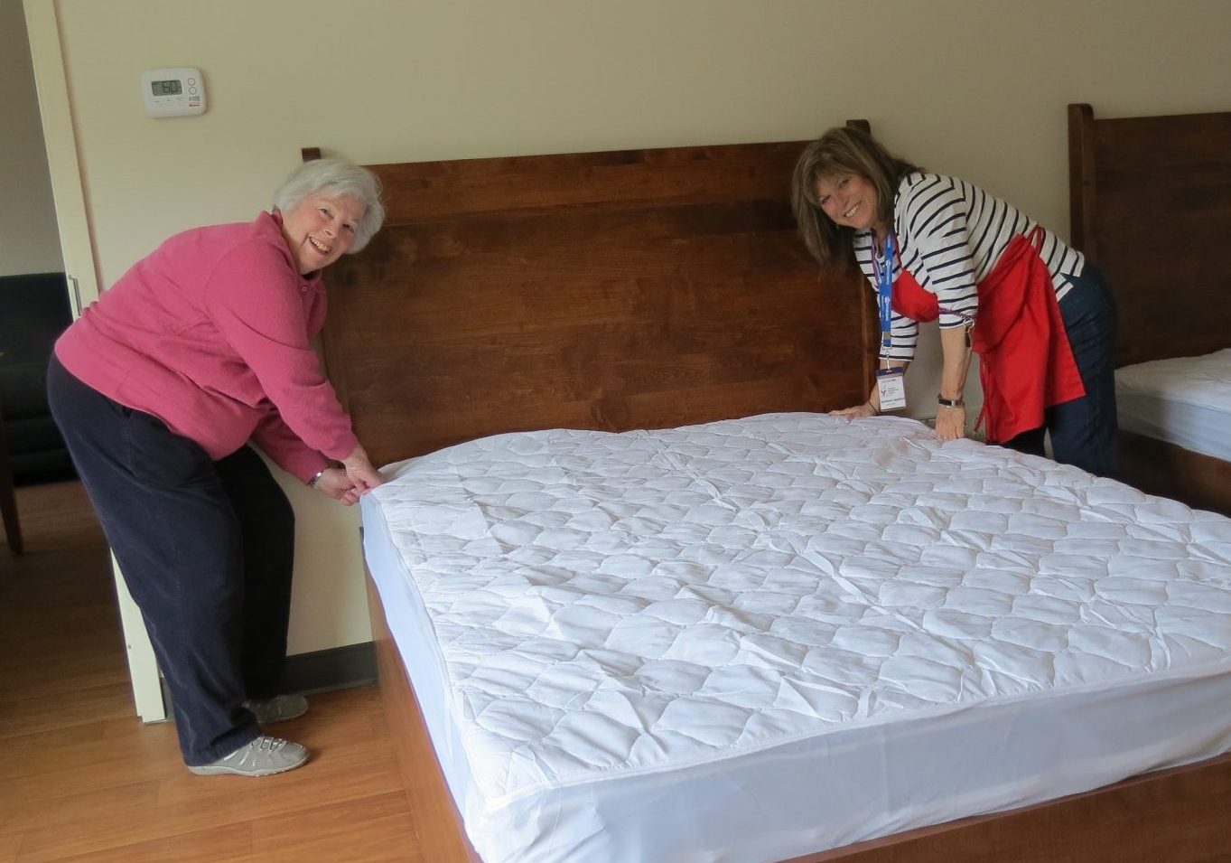 Two women making a bed