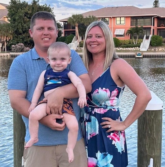 mom dad and baby by lake
